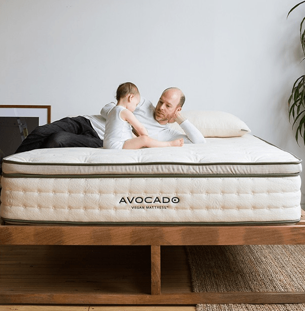 A man and boy laying on a white Avocado mattress