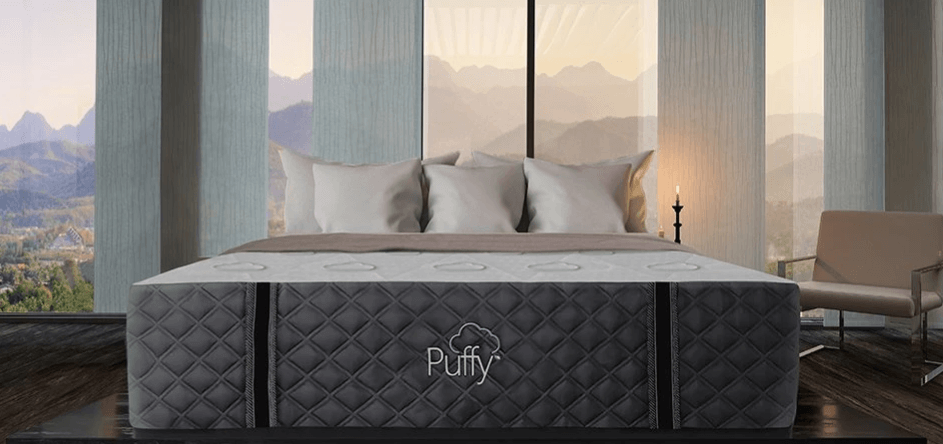 A thick Puffy Royal mattress in a dimly lit room.