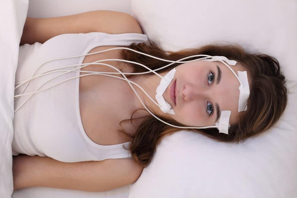 A young woman measuring brainwaves in a sleep laboratory.