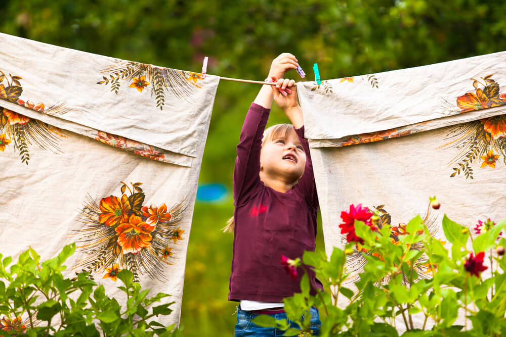 Funny little girl with the clothesline air drying bamboo bed sheets