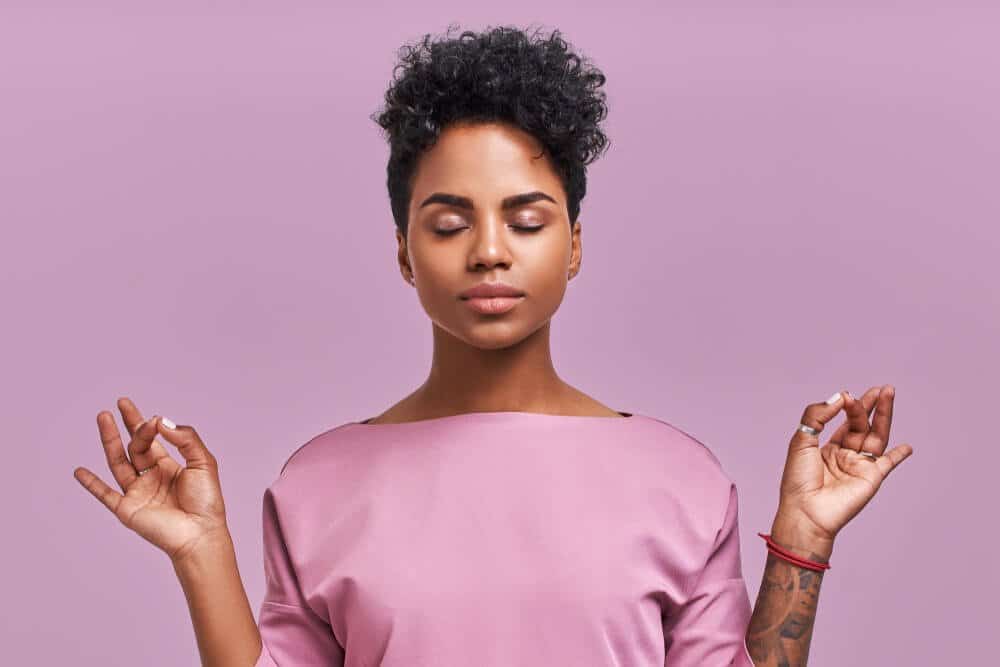 Calm woman relaxing meditating, no stress free relief at work concept, mindful peaceful young businesswoman or student practicing breathing yoga exercises on isolated over lavender background.