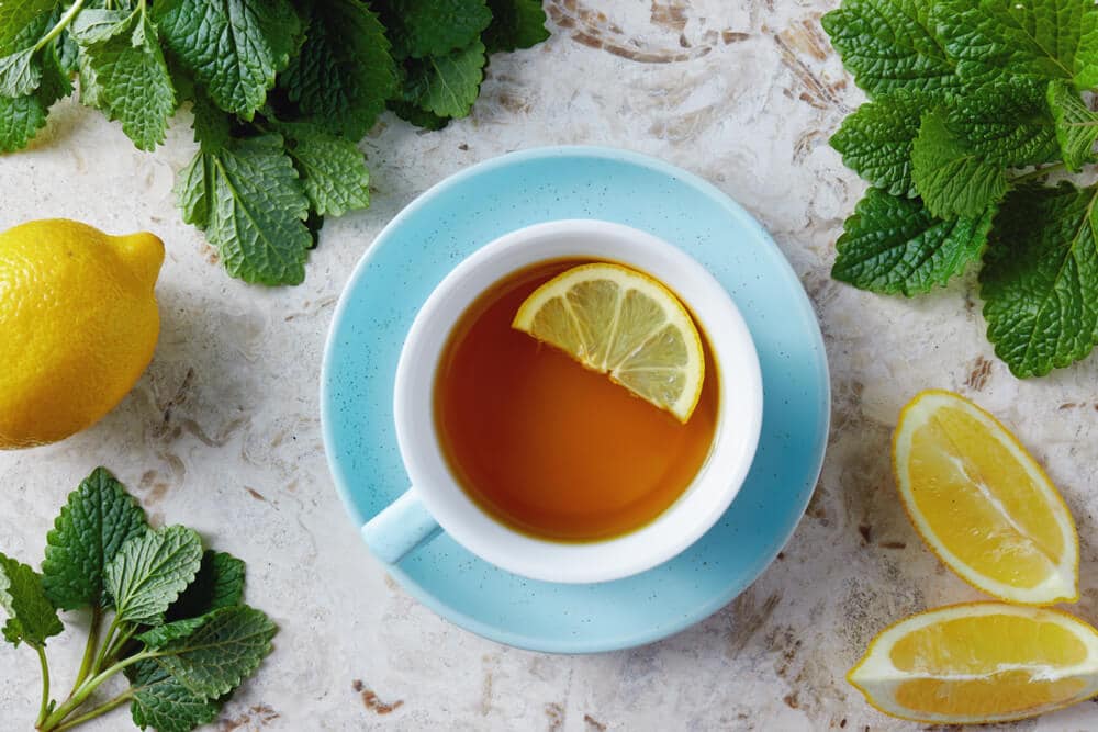 Lemon balm tea with honey. Cup of hot honey lemon balm tea. Lemon balm is a herb that belongs to the mint family and is known for its medicinal benefits.