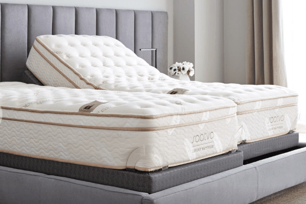 Two white Saatva mattresses on a gray bed frame.