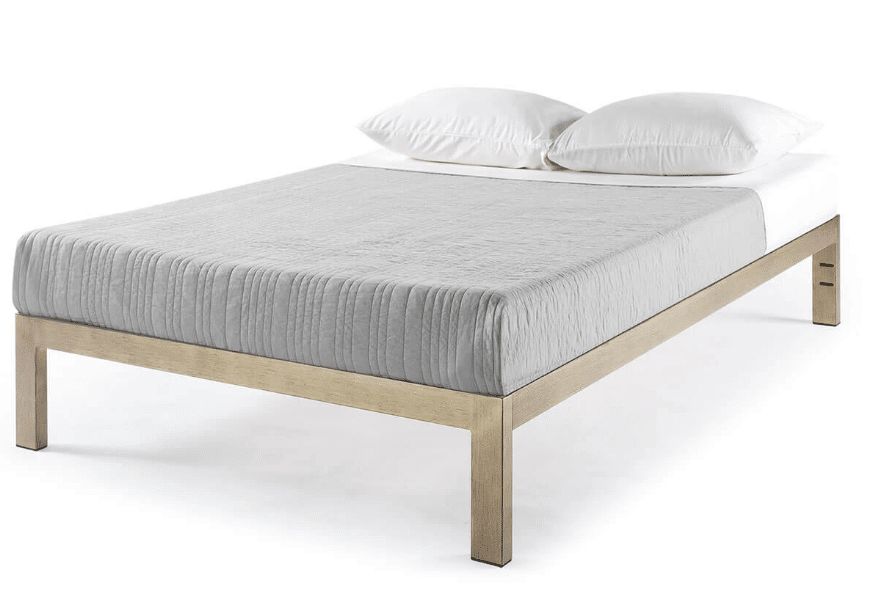 A golden steel bed frame with gray and white bed sheets and two white pillows.