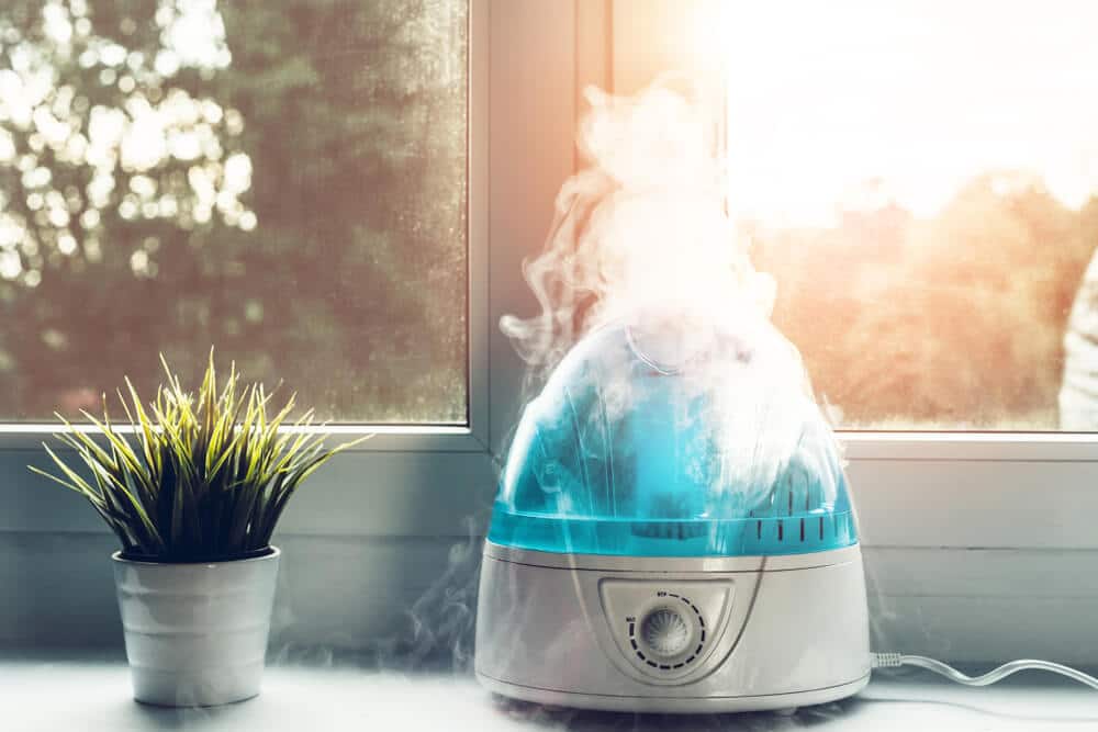 Air humidifier during work. The white humidifier moistens dry air. Improving the comfort of living in the home, apartment. Improving the well-being of people.