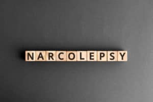 Brown blocks with black letters spelling "narcolepsy" against a black background.