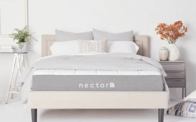 A Nectar mattress lays against a pale bedroom.